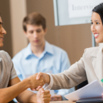 Interviewer shaking college student's hand