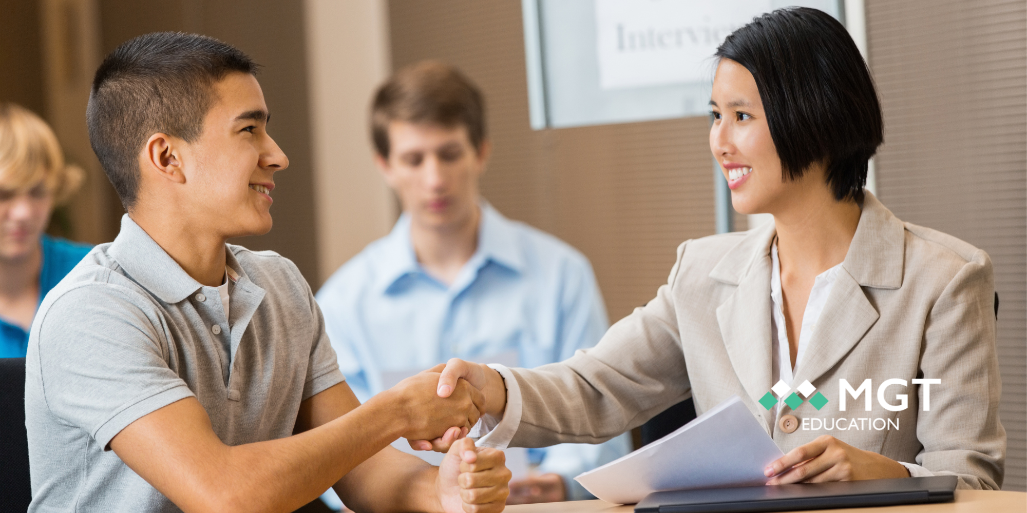 Interviewer shaking college student's hand